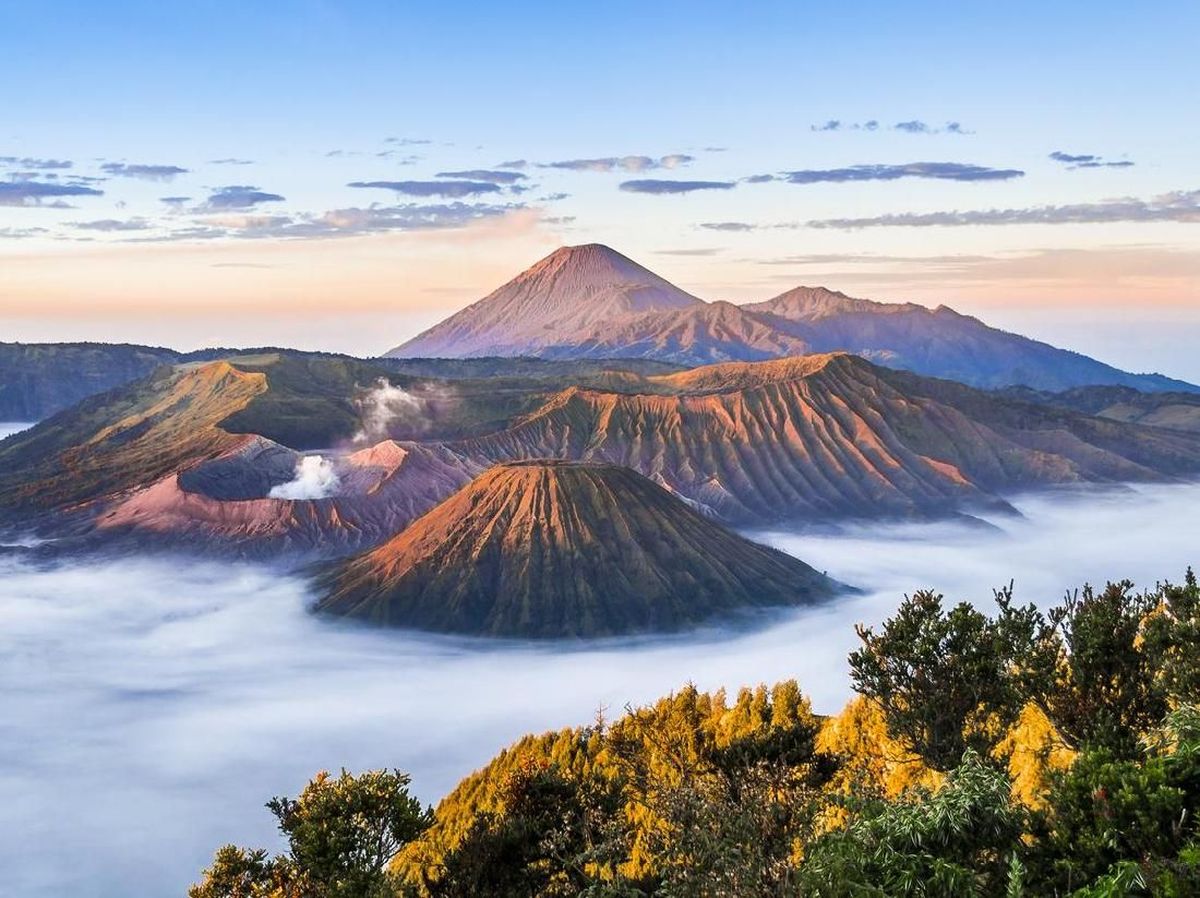 Bromo, Jawa Timur: Sunrise di Gunung Bromo dengan latar lautan pasir dan kawah aktif.