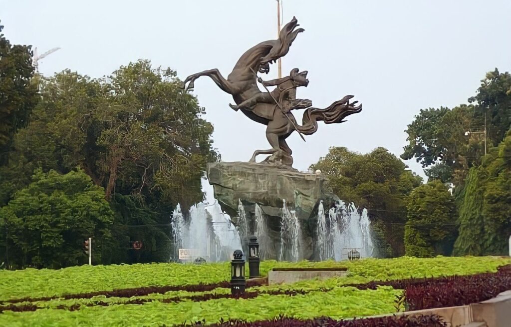 Musisi jalanan tampil di Taman Suropati, Jakarta, dikelilingi pepohonan rindang.